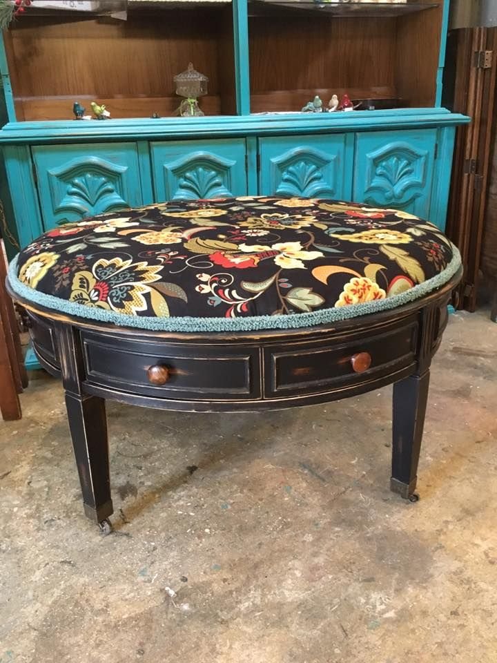 A round upholstered ottoman in teal